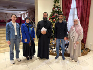 A USAL University delegation posing in front of a Christmas tree during a visit to churches on the occasion of Prophet Jesus’ birth.